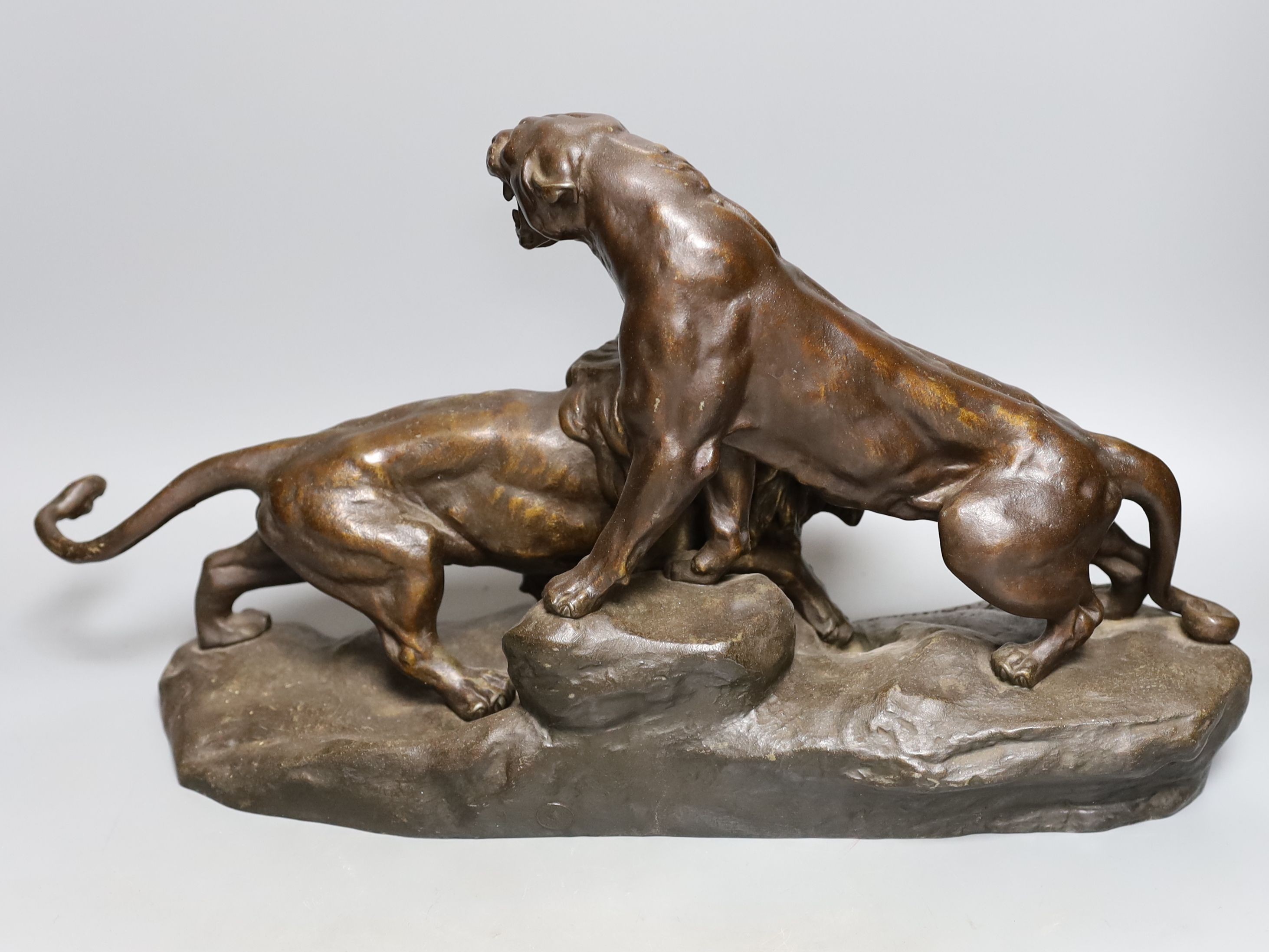A patinated spelter group of a lion and lioness, 53 cms wide.
